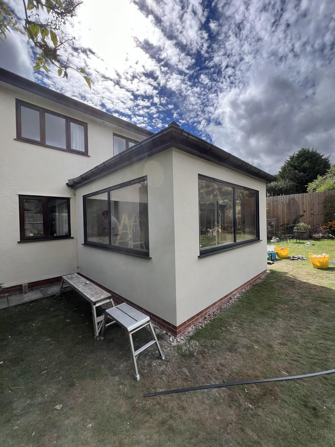 A single-storey extension finished in cream render, with grey windows