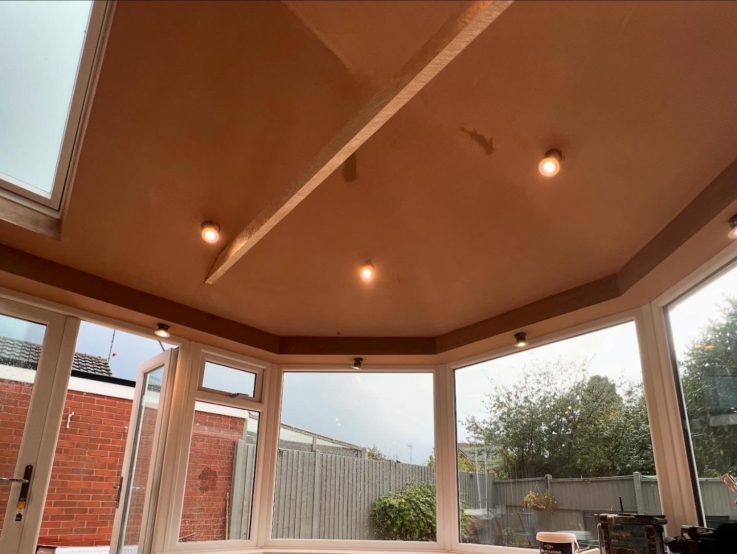 A conservatory ceiling skimmed, with beams and downlights