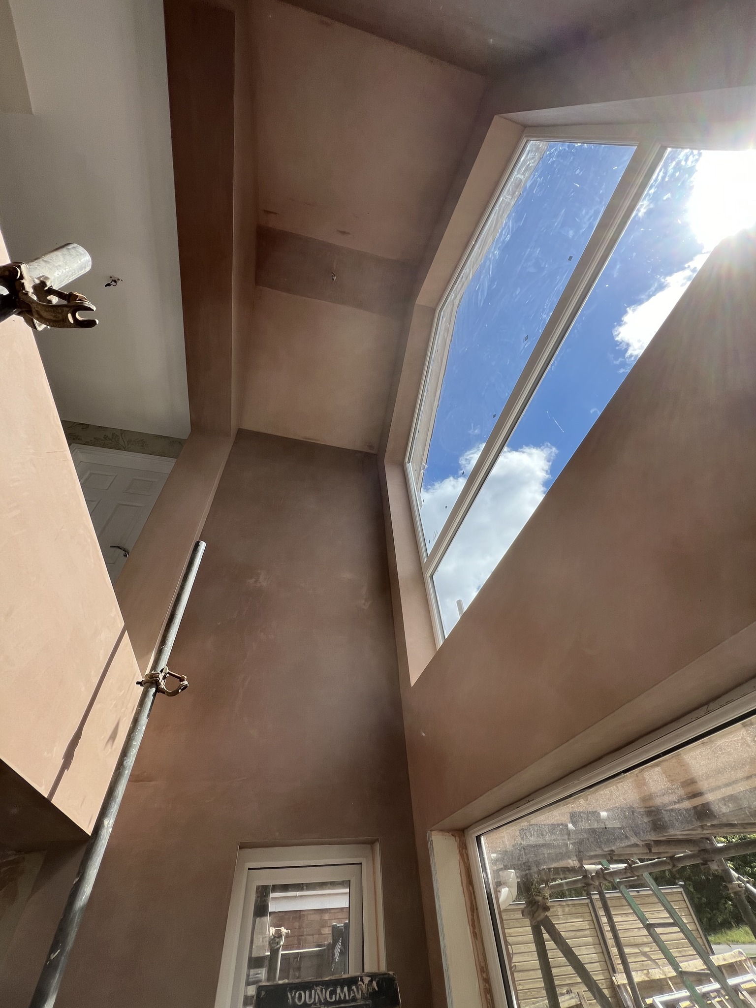 A stairwell with tall windows, newly plastered