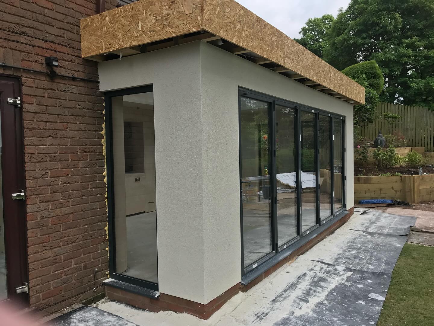 A new extension rendered white, with bi-fold doors