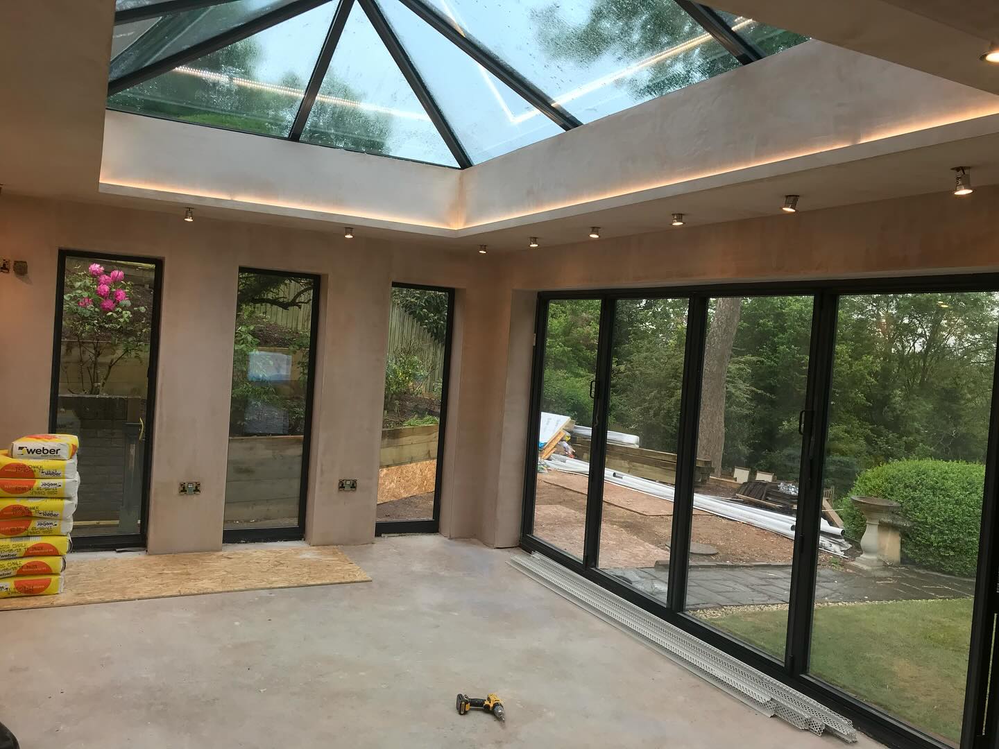 An orangery interior with a glass lantern roof and smooth plaster
